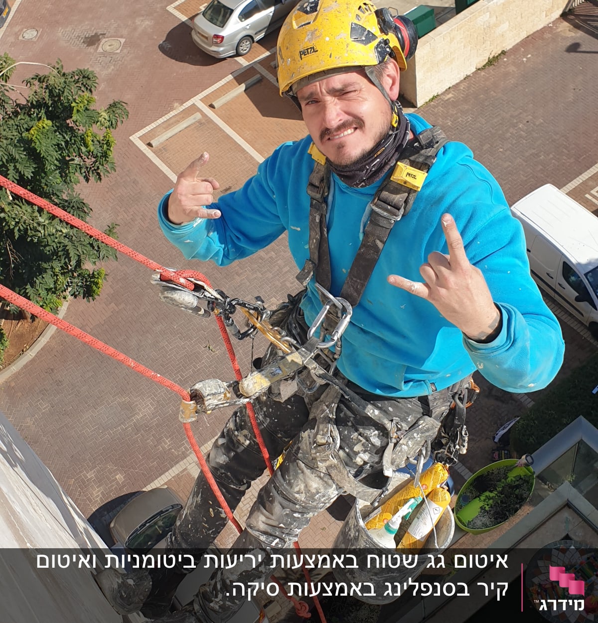 אדם עם קסדה ורתמה על חבל, מחזיק דלי עם חומרי איטום